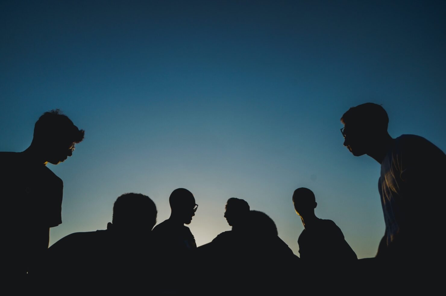People silhouetted against a blue sky.