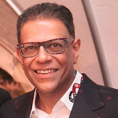 Portrait of a man wearing glasses and a patterned shirt collar.