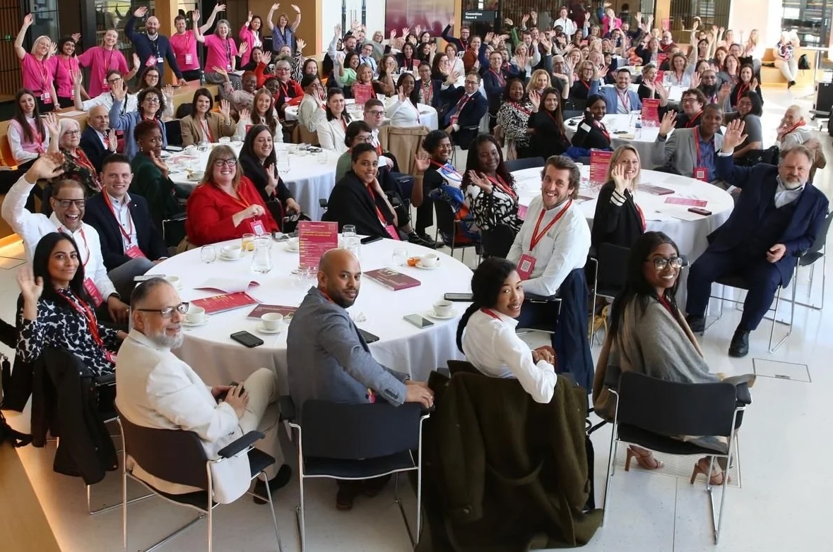 People gathered at an event, waving.