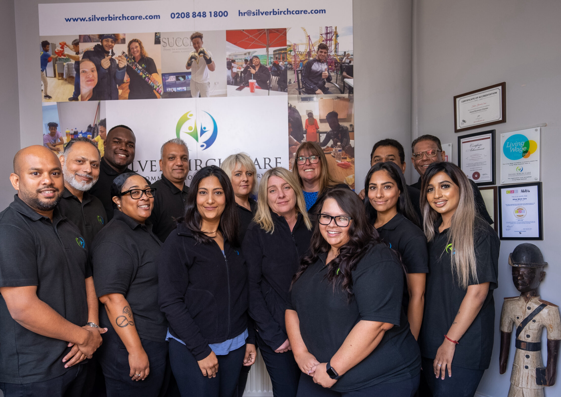 Group of people in black shirts, smiling for photo.